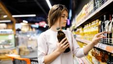 Imagen de archivo de una mujer eligiendo aceite de oliva en un supermercado.
