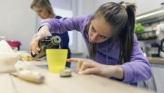 Imagen de archivo de una madre y su hija cocinando con aceite de oliva.