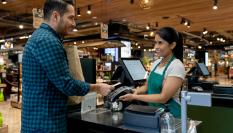 Imagen de archivo de un hombre pagando la compra en la caja de supermercado.