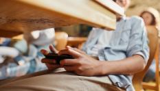 Imagen de archivo de un alumno usando su teléfono móvil en clase.