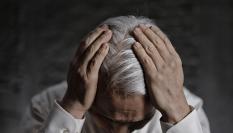 Una persona se toca la cabeza, cuyo cabello se encuentra plagada de canas.