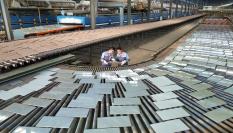 Operarios de una fábrica de cerámica china revisan la producción de azulejos y baldosas.