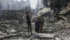 Jóvenes palestinos haciendo una fotografía tras el ataque israelí a un edificio en Gaza.