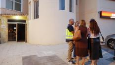 La policía Científica habla con concejales de Málaga en a la entrada del edificio donde han aparecido los cadáveres.
