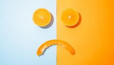 Imagen de archivo de gajos de naranja dibujando un rostro triste.