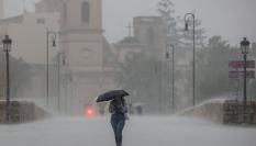 Una persona pasea bajo una tromba en Valencia