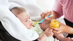Un bebé comiendo un potito, en una imagen de archivo