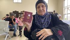 Una mujer muestra su pasaporte español mientras espera a poder salir de Gaza en el paso de Rafah.