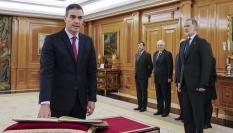 Pedro Sánchez (i) promete su cargo de presidente del Gobierno ante el rey Felipe VI (d) y un ejemplar de la Constitución, este viernes en el Salón de Audiencias del Palacio de la Zarzuela en Madrid.
