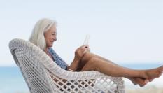 Una mujer leyendo a los pies de la playa