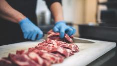 Imagen de archivo de una persona cortando carne.