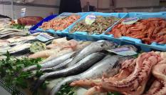 Un pescadero ofrece marisco y pescado.