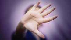 Imagen de una mujer con la mano ocultando su rostro, en gesto de basta ya.