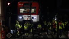 Varios operarios junto al tren de Cercanías que ha descarrilado este martes