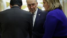 El líder demócrata en el Senado, Chuck Schumer (centro), conversa con varios senadores en los pasillos.