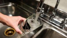 Una persona llena un vaso de agua en Madrid.