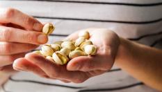 Una persona con un puñado de pistachos en la mano.