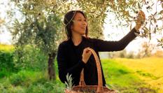 Imagen de archivo de una joven asiática recogiendo olivas.