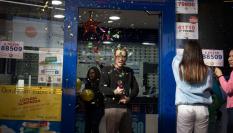 Empleados de una administración de lotería celebran que repartieron el boleto premiado.