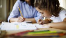 Una profesora dando clase a una joven estudiante.