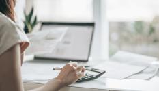 Persona delante de su ordenador calculando tasas.