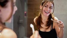 Joven lavándose los dientes en el baño