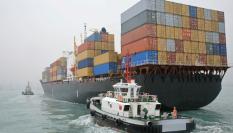 Remolcador navegando junto a un buque portacontenedores en China