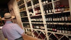 Un hombre, dispuesto a comprar vino español en una vinoteca.