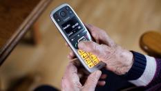 Una persona mayor con un teléfono.