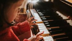 Imagen de archivo de una niña tocando el piano.