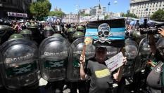 Un manifestante posa con su cartel delante del dispositivo policial este miércoles en Buenos Aires