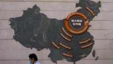 Una mujer pasa junto a un mapa que muestra los proyectos de Evergrande en China.