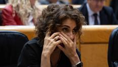 La vicepresidenta María Jesús Montero habla por teléfono en una sesión plenaria del Senado.