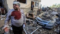 Un palestino comprueba daños en las viviendas, tras un ataque israelí sobre Rafah (Gaza).