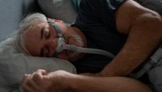 Un hombre que sufre apena del sueño durmiendo.