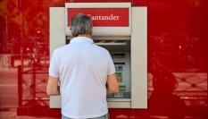 Un hombre utiliza uno de los miles de cajeros automáticos distribuidos por España.