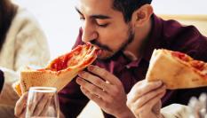 Hombre disfrutando de una pizza