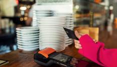 Una persona pagando en un establecimiento hostelero.