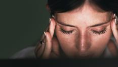 Una mujer sufriendo migraña.