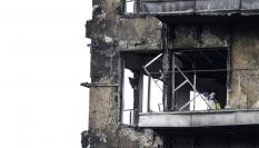 Un agente de la Policía Científica inspecciona una vivienda del edificio incendiado en el barrio de Campanar de Valencia