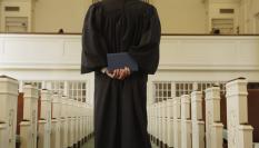 Imagen de un cura, de espaldas.