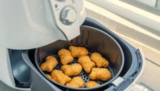 Imagen de archivo de una freidora de aire, con 'nuggets' de pollo.