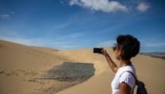 Imagen de archivo de una mujer tomándose un selfi en las dunas de Maspalomas (Las 
 Palmas de Gran Canaria).
