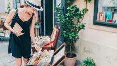 Imagen de una mujer ojeando libros de segunda mano.