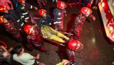 Traslado de uno de los heridos en el incendio de un edificio comercial de Bangladesh.