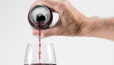 Imagen de archivo de una persona vertiendo un vino de lata en una copa.