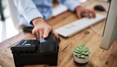 Una persona cogiendo el teléfono en el trabajo.