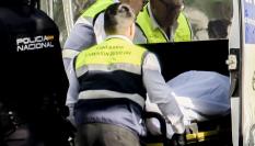 Captura de vídeo de los miembros de la funeraria y de la Policía Nacional que trasladan el cuerpo de un joven de 21 años que ha fallecido este domingo en la capital de Sevilla.