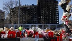 Detalle de flores, velas y peluches colocados a modo de homenaje ante el edificio incendiado en el barrio de Campanar de València en el que murieron diez personas y deja más de 400 damnificados.