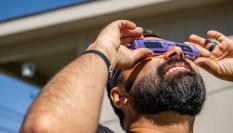 Un hombre dirige su mirada hacia el sol, protegido con unas gafas especiales, en el último eclipse solar.